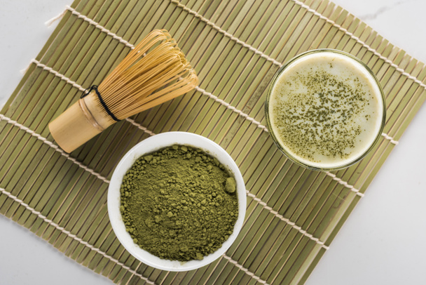 felülnézet a zöld Matcha tea por és ital az üveg bambusz mat - Fotó, kép