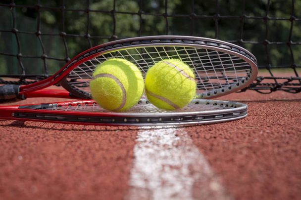 Tennis scene with black net, balls and racquet - Foto, afbeelding