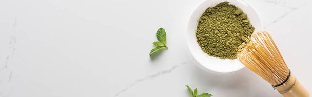 top view of matcha tea powder and mint on white table - Foto, afbeelding