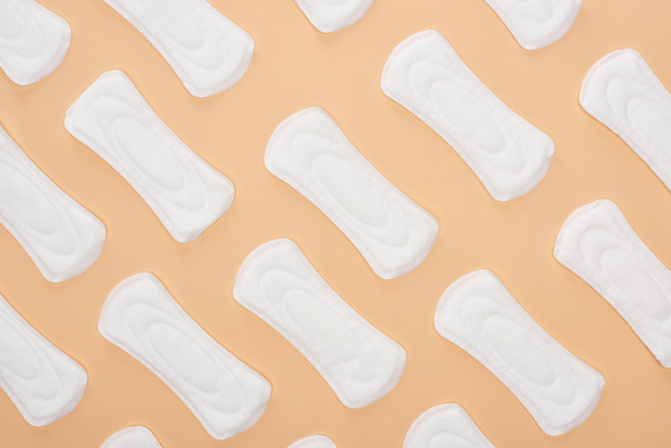 бесшовный узор с белыми хлопчатобумажными санитарными полотенцами, изолированными на бежевом
 - Фото, изображение