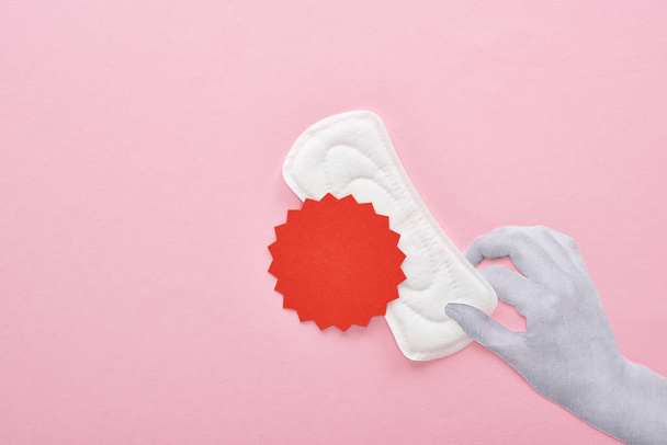 cropped view of hand holding white sanitary napkin with blood sign on pink background - Photo, Image