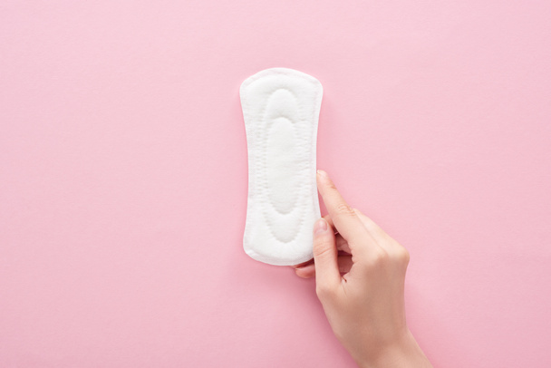 cropped view of woman holding white sanitary napkin on pink background - Фото, зображення