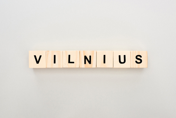 top view of wooden blocks with Vilnius lettering on white background - Foto, afbeelding