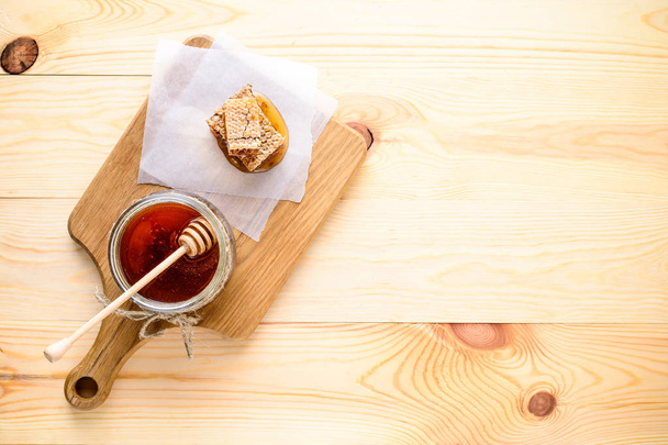 honey with dipper on wooden background - Fotó, kép