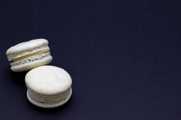 Colorful macaroons or macaroni cake on a dark background. A french sweet delicacy - Foto, imagen