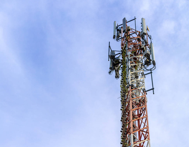 κινητό τηλέφωνο επικοινωνίας και ραδιοαναμεταδότης σήμα αναμεταδότη κεραία με μπλε ουρανό φόντο - Φωτογραφία, εικόνα