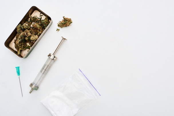 vista dall'alto di germogli di marijuana, eroina e siringa su sfondo bianco
 - Foto, immagini