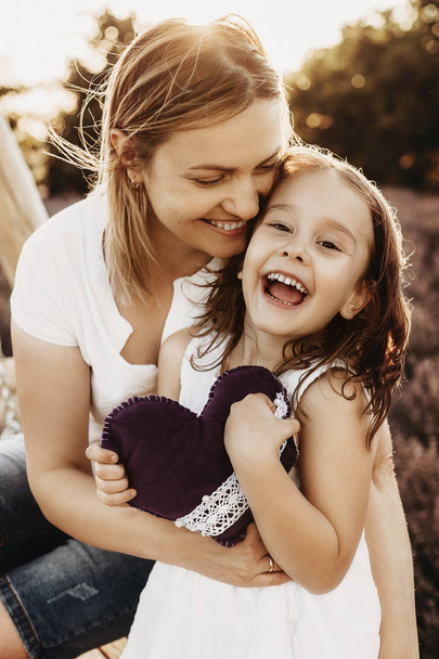 Close up portrait of a lovely mother and daughter embracing and  - Foto, Imagen