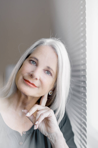stunning beautiful and self confident best aged woman with grey hair smiling into camera, portrait  - Fotó, kép
