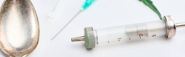 close up view of spoon, syringe and needle on white background, panoramic shot - Fotó, kép