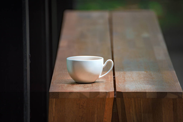 Чашка белого кофе на столе с Bokeh Природа фон
 - Фото, изображение