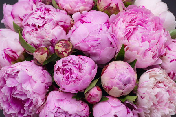 Pink peonies in a hat box on a dark background. - Photo, Image