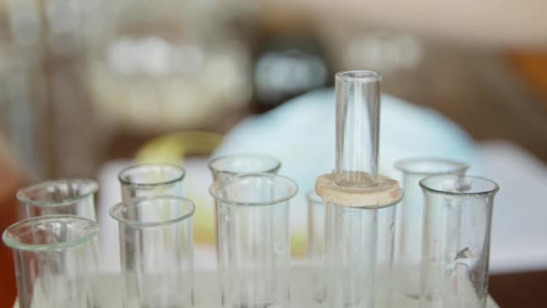 In a university / school laboratory, a student with a pipette analyzes a liquid in the test tubes. Concept: research, biochemistry, study, chemist - Séquence, vidéo