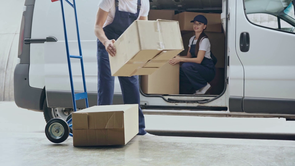 levering vrouw geven pakketten en man putting dozen op handtruck - Video