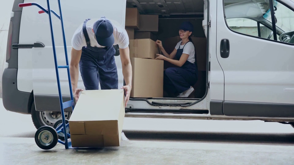 Dostawa człowiek biorąc pudełka z ręki ciężarówki i dając do dostawy Kobieta w samochodzie  - Materiał filmowy, wideo