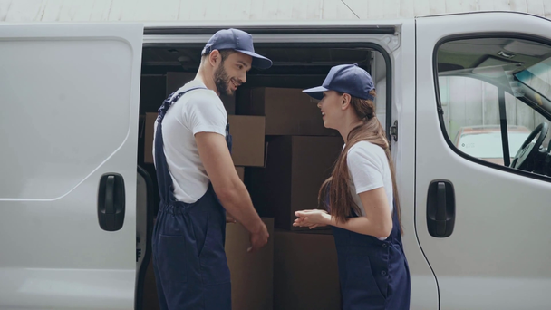 arabada kutuları n yanında konuşan neşeli teslimat işçileri - Video, Çekim