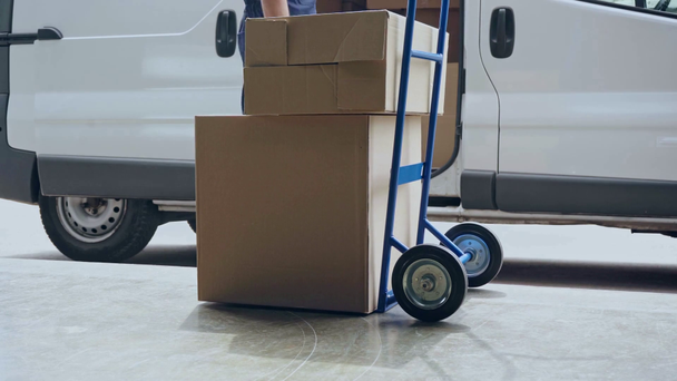 visão cortada do homem de entrega colocando caixas de papelão no caminhão de mão
 - Filmagem, Vídeo
