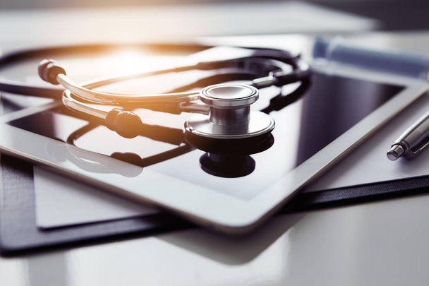 Healthcare and technology concept - tablet and stethoscope on white table - Foto, immagini