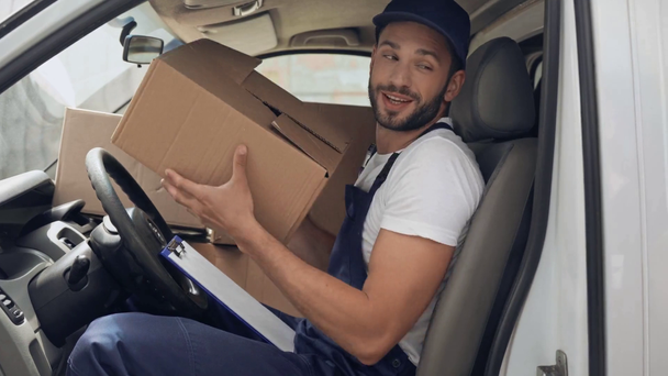 delivery man praat met de klant en het geven van pakjes in de auto - Video