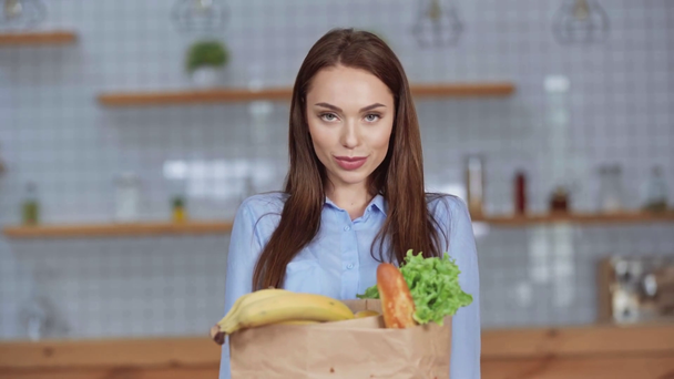 krásná veselá žena s papírovým pytlem s potravinami - Záběry, video