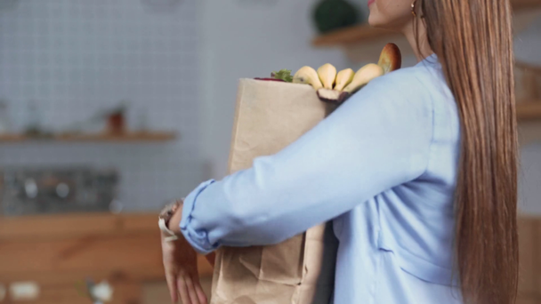 wykadrowany widok uśmiechnięta kobieta otrzymująca dostawę artykułów spożywczych w domu - Materiał filmowy, wideo