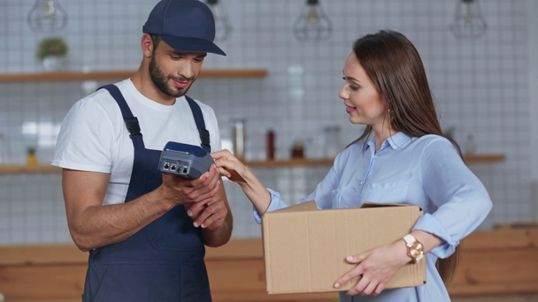 delivery man giving credit card reader and parcel to woman - Filmmaterial, Video