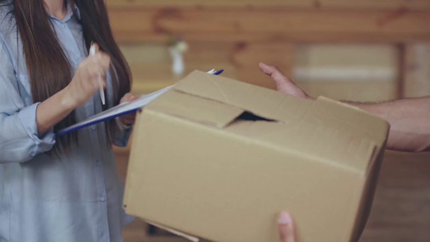 paket veren teslimatçı nın kırpılmış görünümü ve imza atan kadın - Video, Çekim