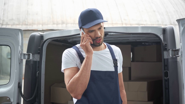 Dostawa człowiek rozmawia na smartphone w pobliżu samochodu z paczek - Materiał filmowy, wideo