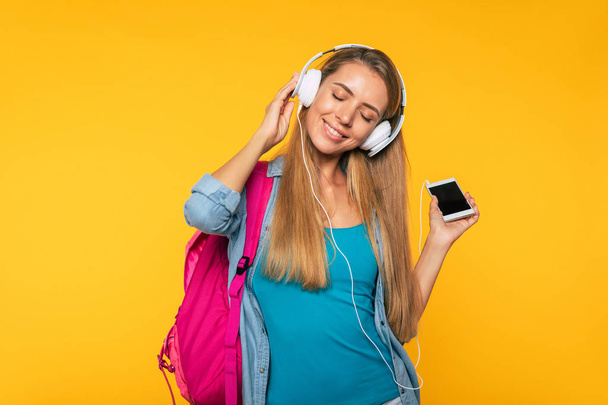 Study, education, university, college, graduate concept on yellow background. Portrait of beautiful smiling blonde woman. Young student with backpack - Φωτογραφία, εικόνα