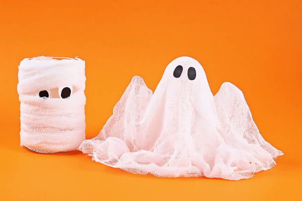 Halloween ghost of starch and gauze on orange background. Gift idea, decor Halloween. - Photo, Image