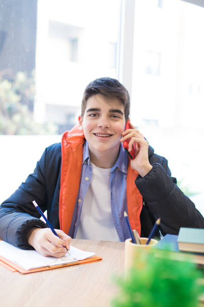 opiskelija, jolla on matkapuhelin puhuu puhelimessa
 - Valokuva, kuva