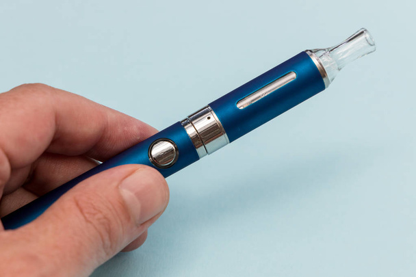 Hand hält Vape Pen Metall elektronische Zigarette mit Dampf blu - Foto, Bild