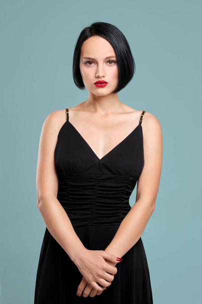 Beautiful girl with short dark hair and red lips posing in studio - Photo, Image