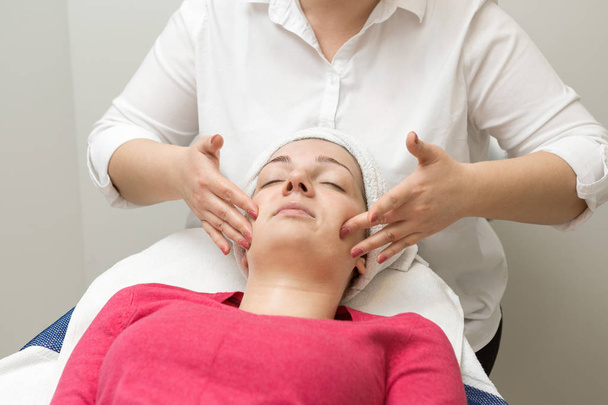 Young woman receiving facial massage at spa salon - Foto, imagen