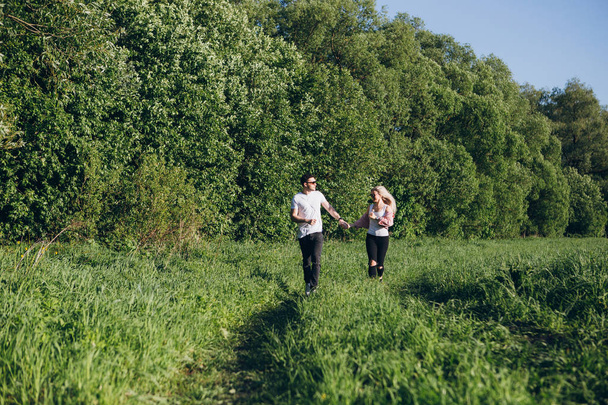 Couple guy and girl running hand in hand on the road in nature - Fotoğraf, Görsel