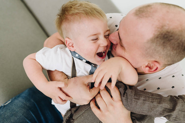 Vader speelt met zijn zoon, lachen, zoenen - Foto, afbeelding
