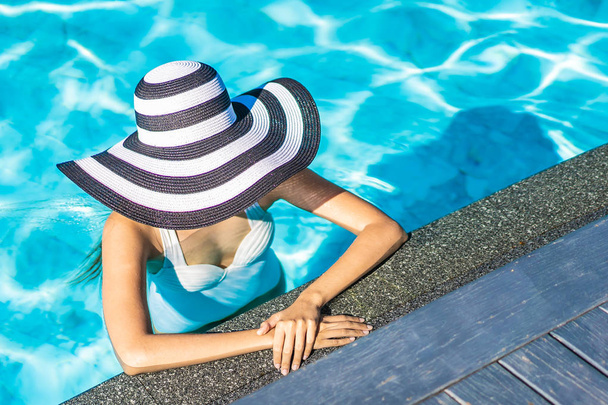 Bella giovane donna asiatica con cappello in piscina per i viaggi
 - Foto, immagini