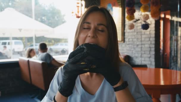 Голодна дівчина їсть чорний бургер у ресторані фаст-фуду. 4K Повільний рух
. - Кадри, відео