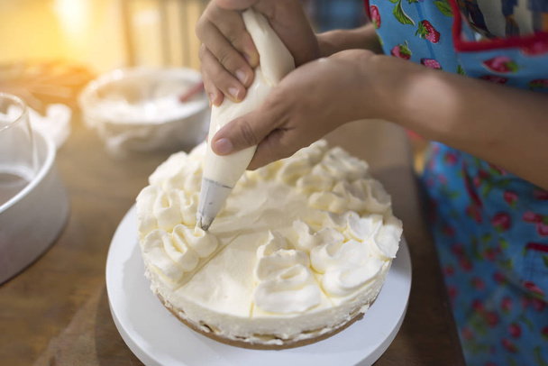 Női kézi díszítő egy zsák péksütemény, tejszín - Fotó, kép