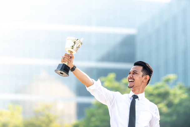 El empresario malayo gana un trofeo. Concepto de empleado superior
 - Foto, Imagen