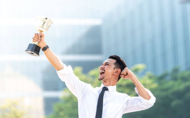 Uomo d'affari malese vince un trofeo. Top concetto dipendente
 - Foto, immagini