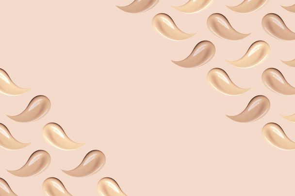 Makeup smears on beige background. Nude foundation smudges isolated. Skin tone BB, CC cream texture. Liquid make up base strokes. Creamy cosmetic beauty product swatch pattern. - Fotó, kép