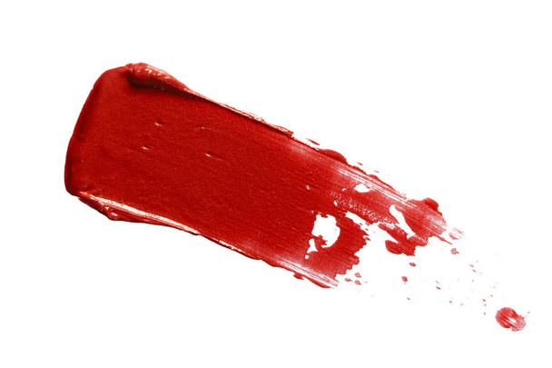 Red lipstick smear smudge swatch isolated on white background. Cream makeup texture. Bright color cosmetic product stroke swipe sample - Фото, зображення