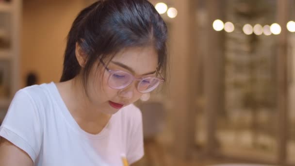 Aziatische student vrouwen lezen boeken in bibliotheek aan de Universiteit. Jonge undergraduate meisje doen huiswerk, lezen leerboek, studeren hard voorkennis op het College Bureau op de campus overuren nacht. Slow Motion. - Video