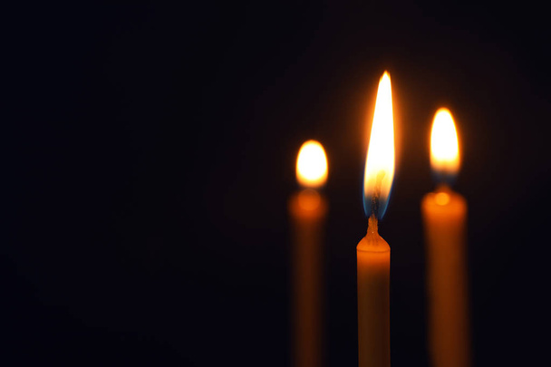 Burning candles on dark background, space for text. Symbol of sorrow - Φωτογραφία, εικόνα