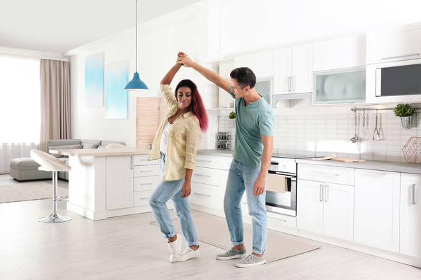 Beautiful couple dancing in kitchen at home - Foto, afbeelding
