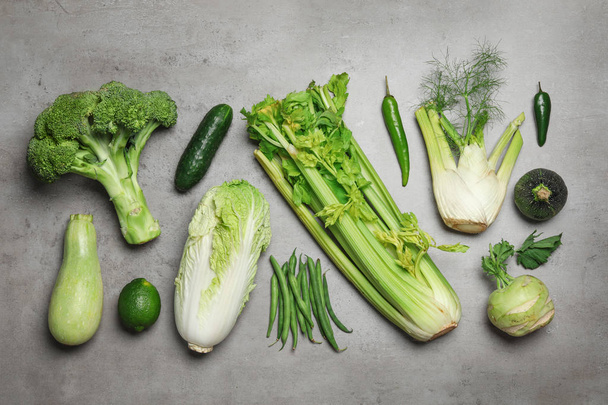 Composición plana de las diferentes verduras verdes en la mesa gris
 - Foto, imagen