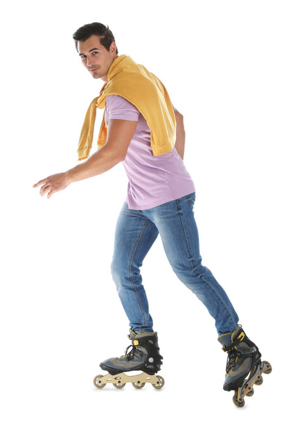 Handsome young man with inline roller skates on white background - Фото, изображение