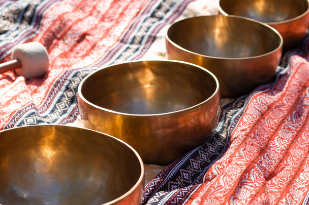 Indian Tibetan bronze healing bowls lie on a sari in perspective - 写真・画像