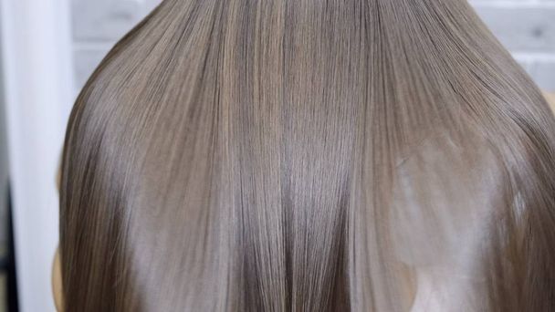 Výsledek po laminování a vyhlazování vlasů v salonu krásy pro dívku s hnědými vlasy. koncepce péče o vlasy - Fotografie, Obrázek